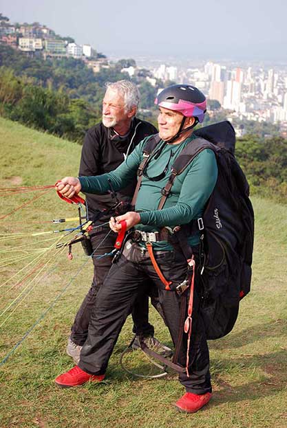 Imagem representando Instrutor dando curso de parapente a aluno
